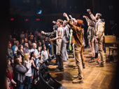 The Hadestown raises a glass to the audience at the end of the show. Catch them in action at Broadway's Walter Kerr Theatre.